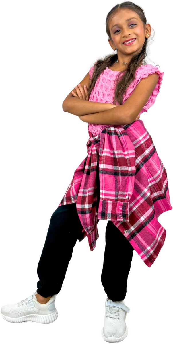Young dancer in a pink top and plaid shirt tied at the waist, arms folded